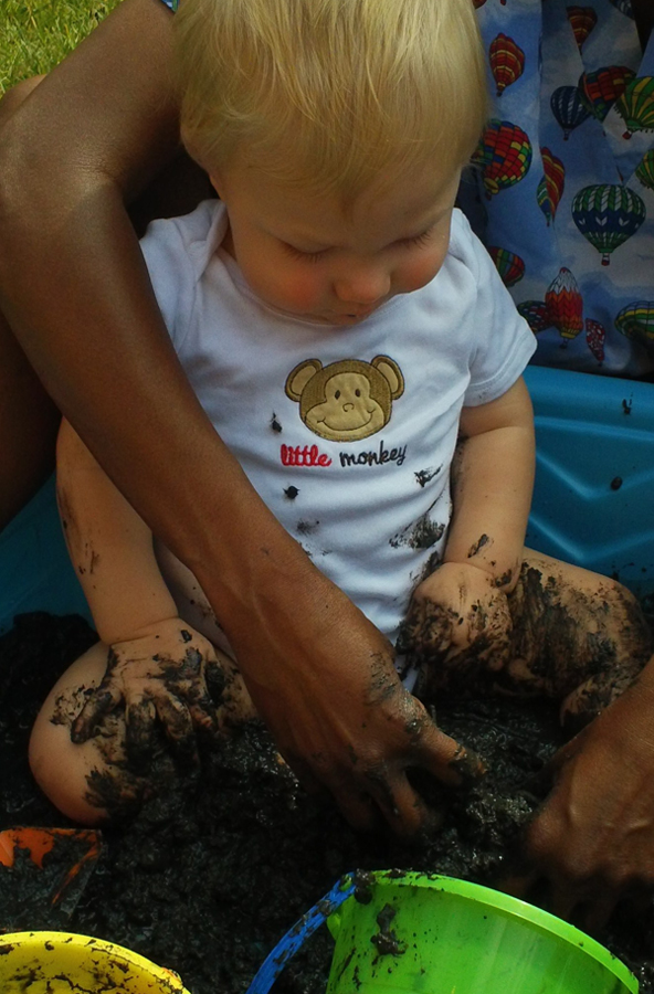 toddler engaging in mud play