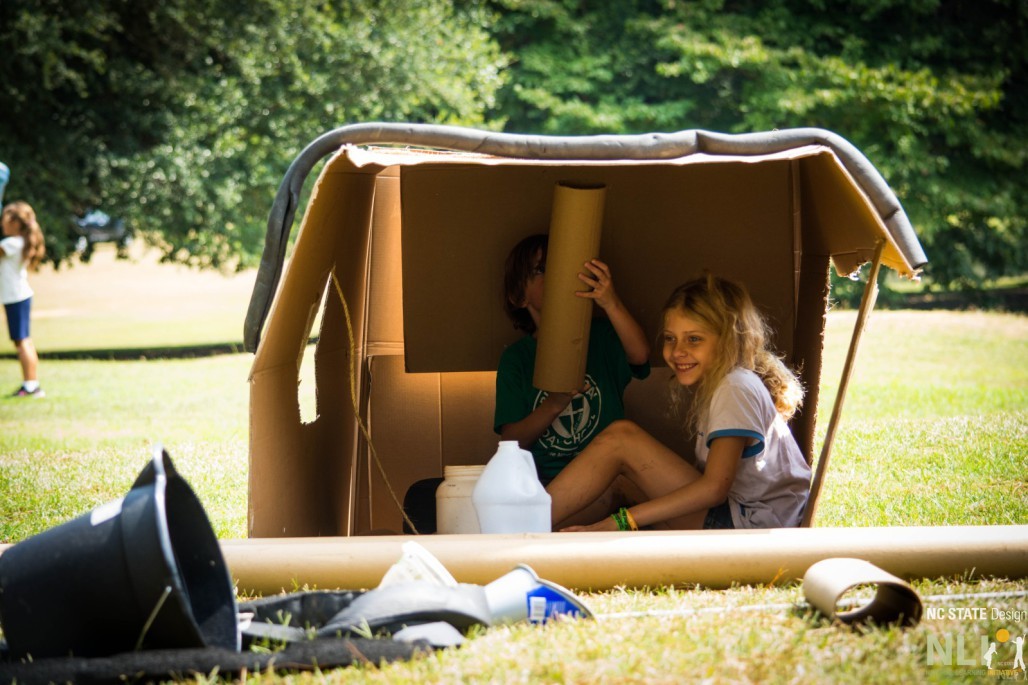 children in a cardboard fort
