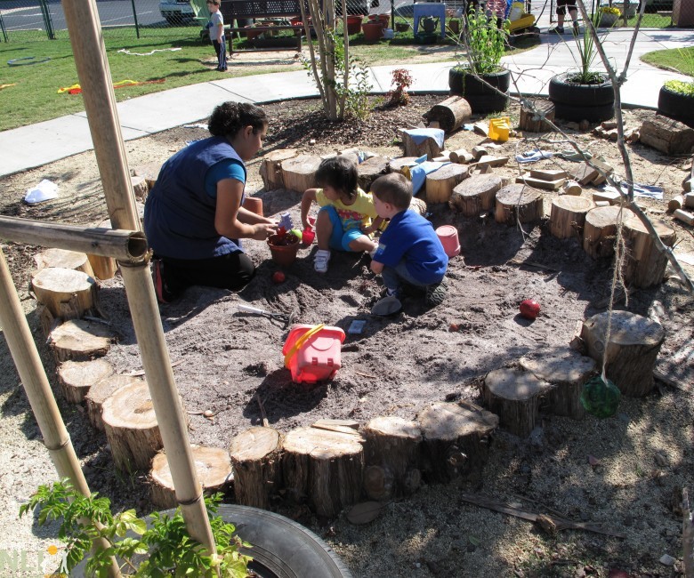 children and adult engaging in dirt play