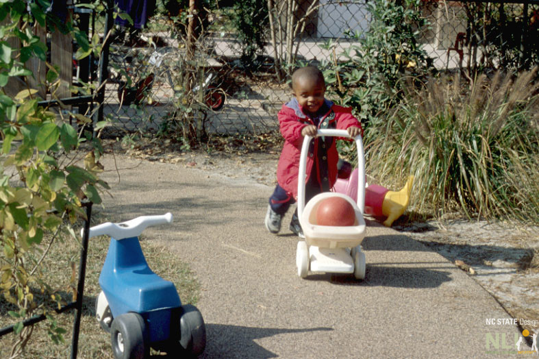 child using standing wheeled toy