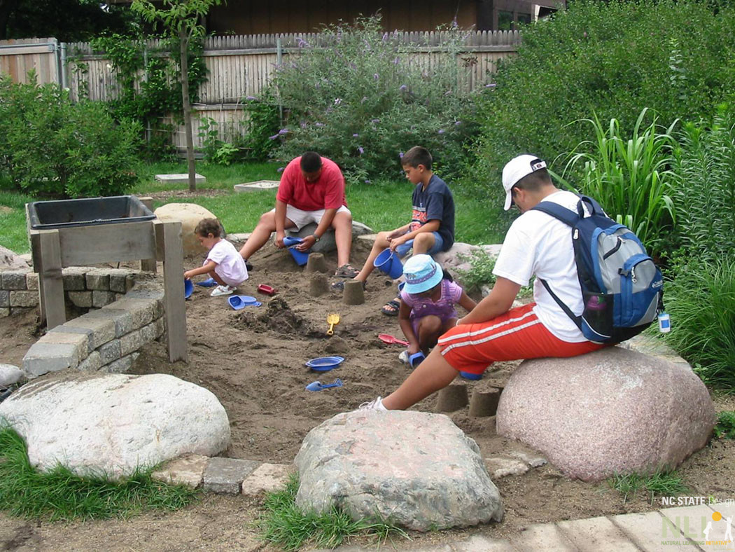 people sitting on boulders and children engaging in earth play
