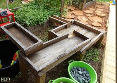 Raised-trough water play setting with pebbles