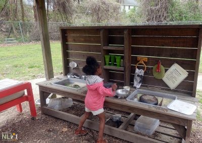child playing in a mud kitchen