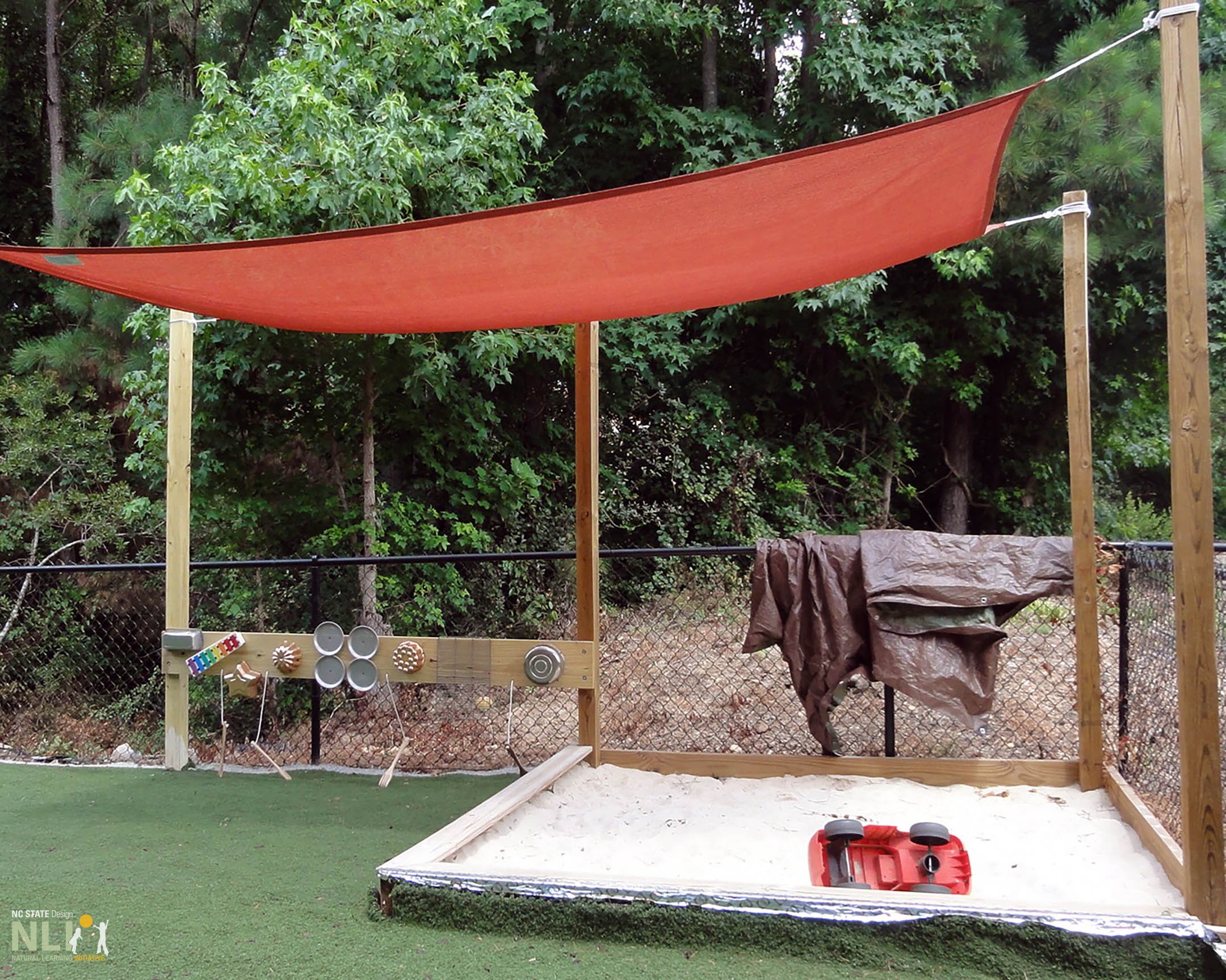 Sand and acoustic play with a shade sail