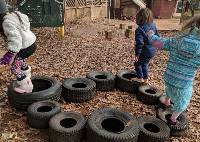 children balancing on tires