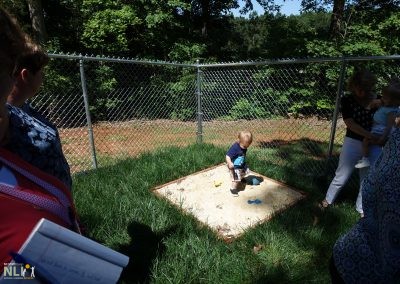 toddler standing in a sand play area