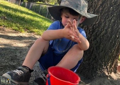 child playing in the dirt with a bucket