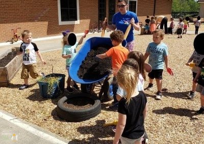 children assisting adult in creating tire planters