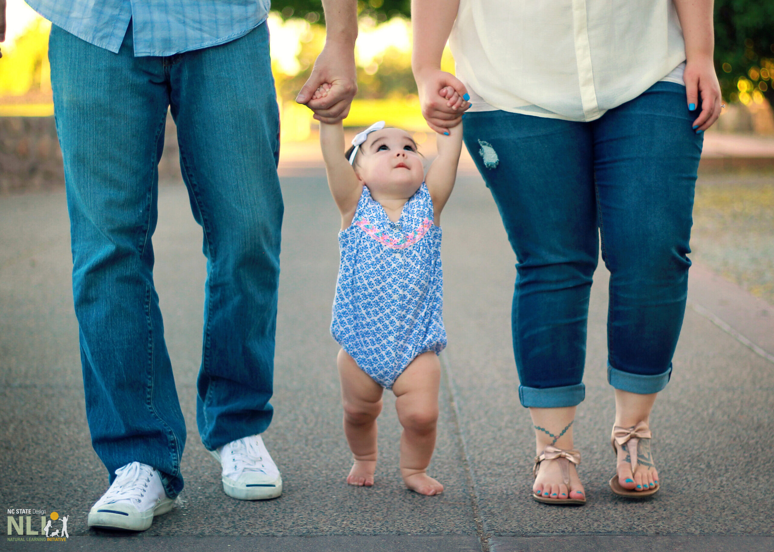 parents holding toddler's hands