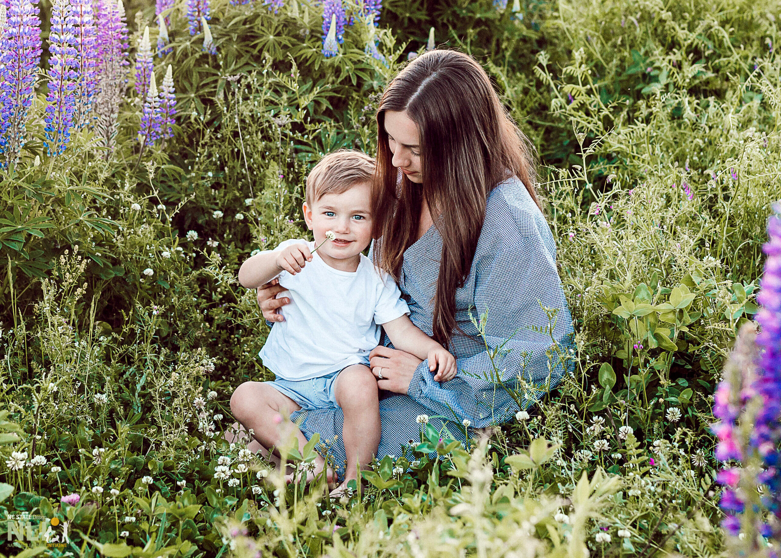 parent and toddler sitting in a flower garden