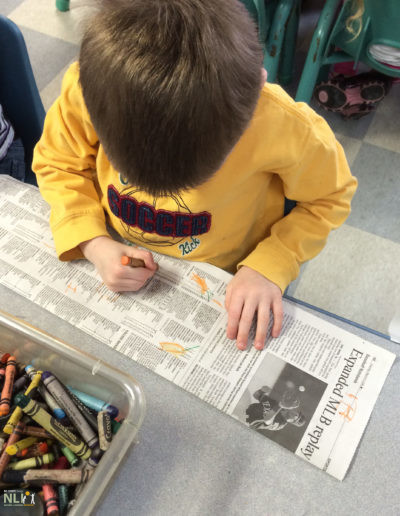 child drawing on newspaper