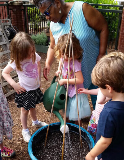 children and adult watering plants