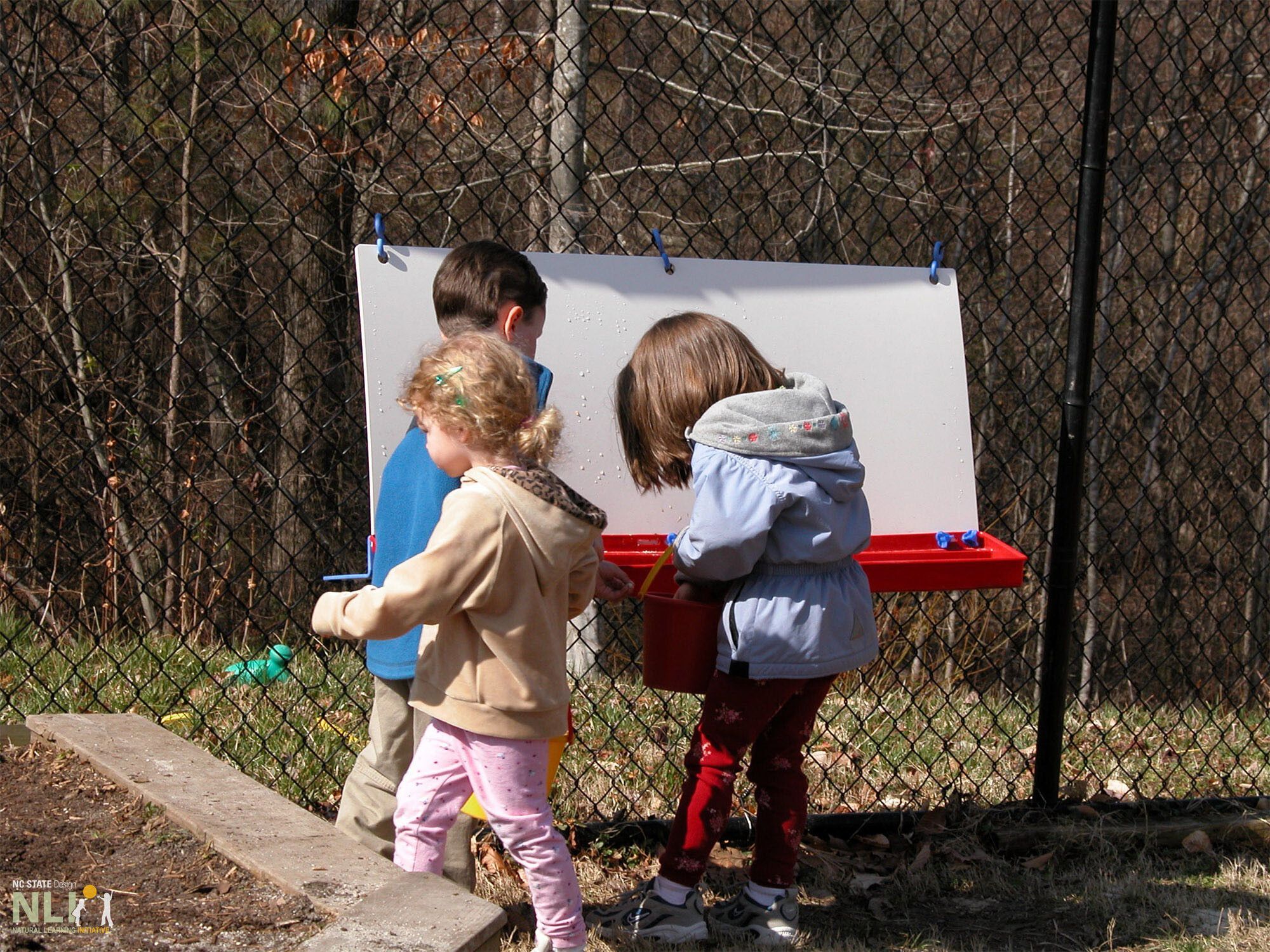 children engaging in ice play with a canvas ouside