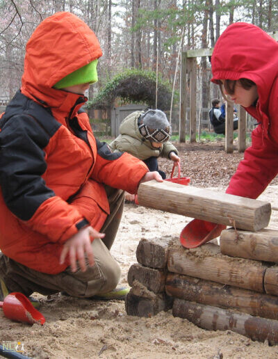 children stacking wooden logs