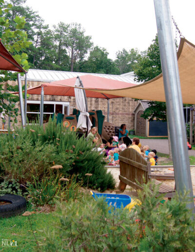 children and caregivers with children under shade structures