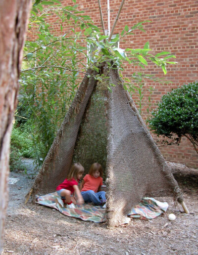 children in a conical structure covered in fabric