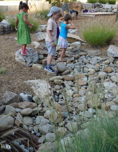 children playing on a dry stream bed
