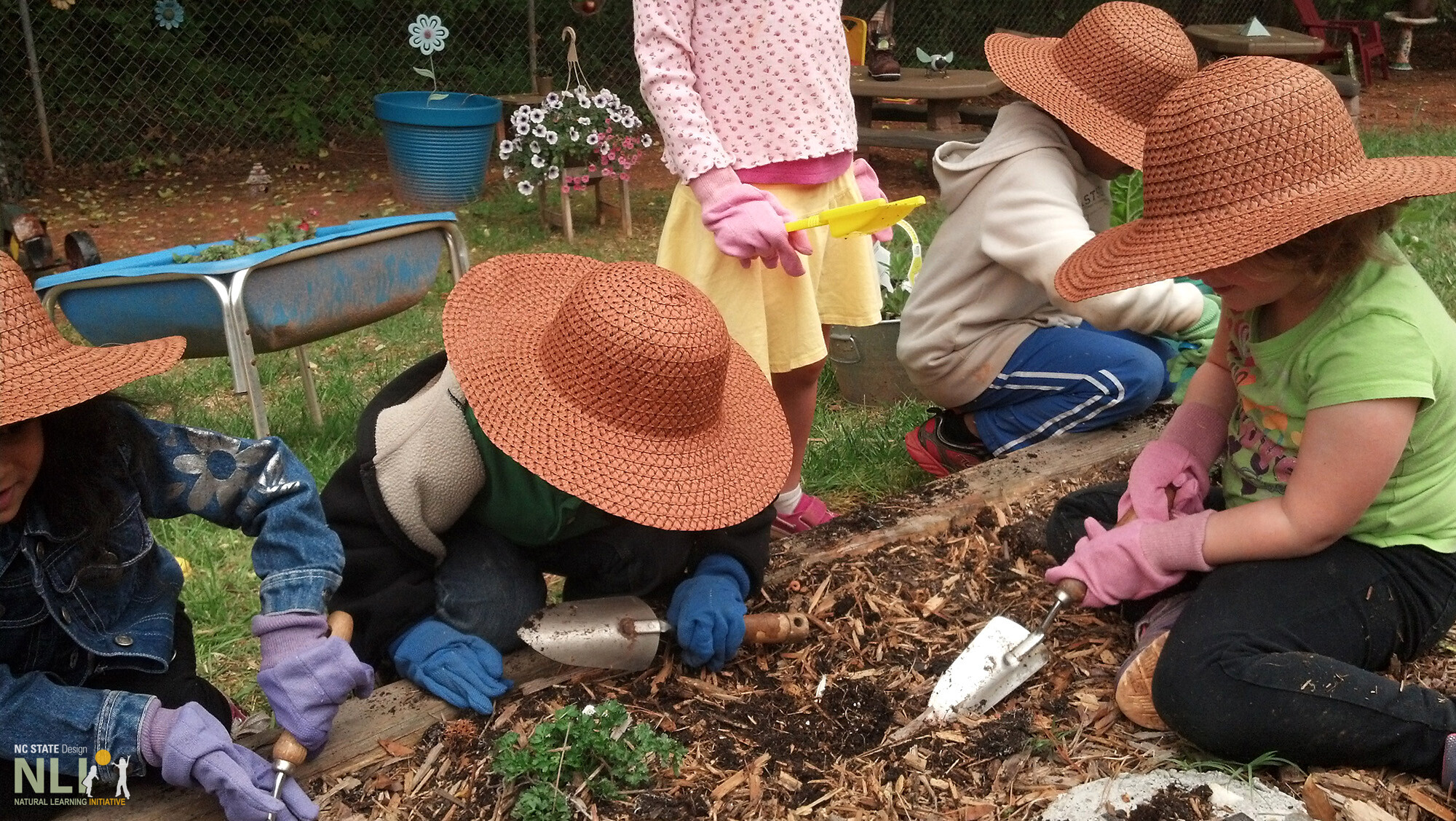 children digging in garden with trowels
