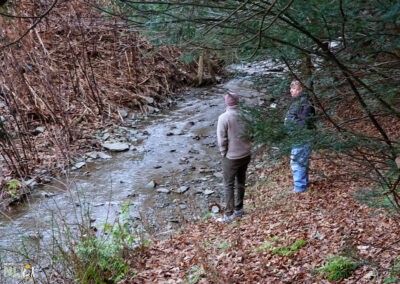 adults observing creek